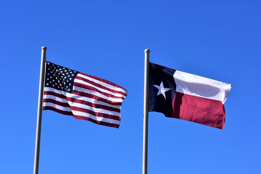 Texas and US flags blowing in the wind
